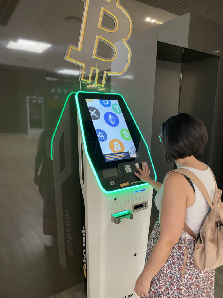 Person using a Bitcoin ATM in Canada to show how to buy Bitcoins with cash
